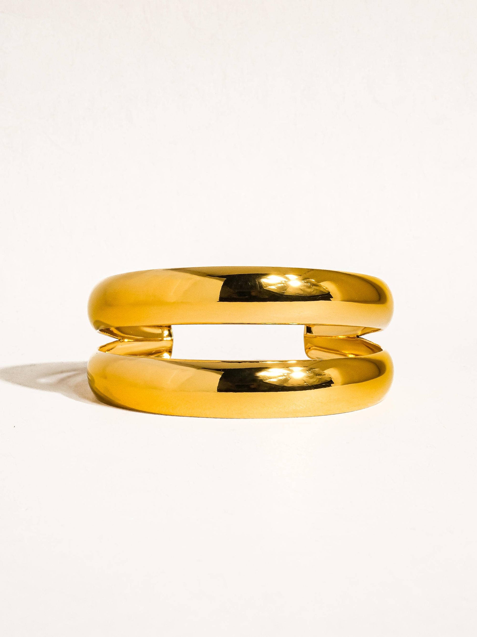Ronan 18K gold layered round bangle by Flanerie by MAIQ, showcasing a sleek, non-tarnish gold finish on a stylish jewelry piece.