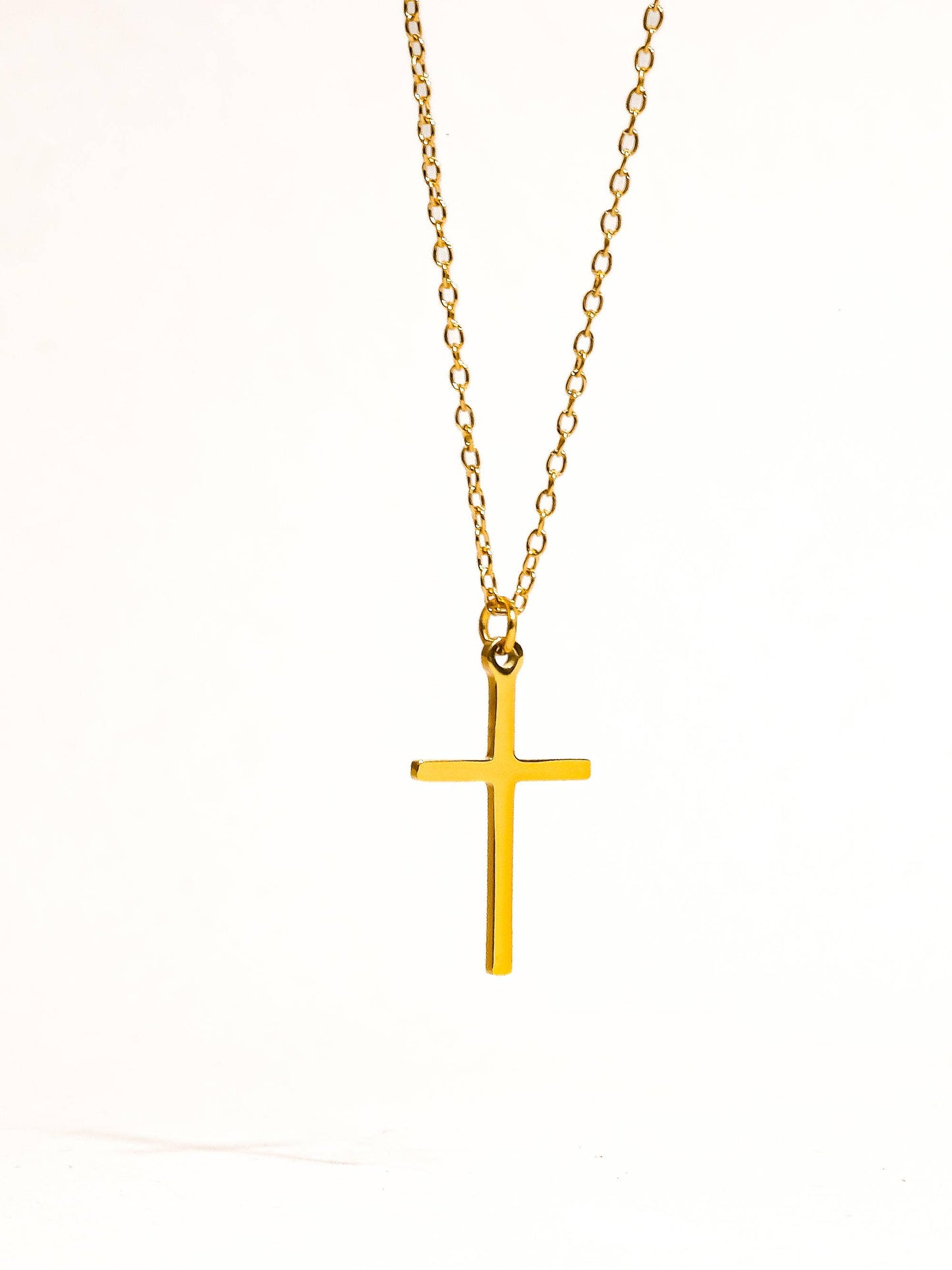 Flanerie by MAIQ Tirza 18K gold small cross necklace with non-tarnish finish, featuring a delicate chain and minimalist cross pendant.