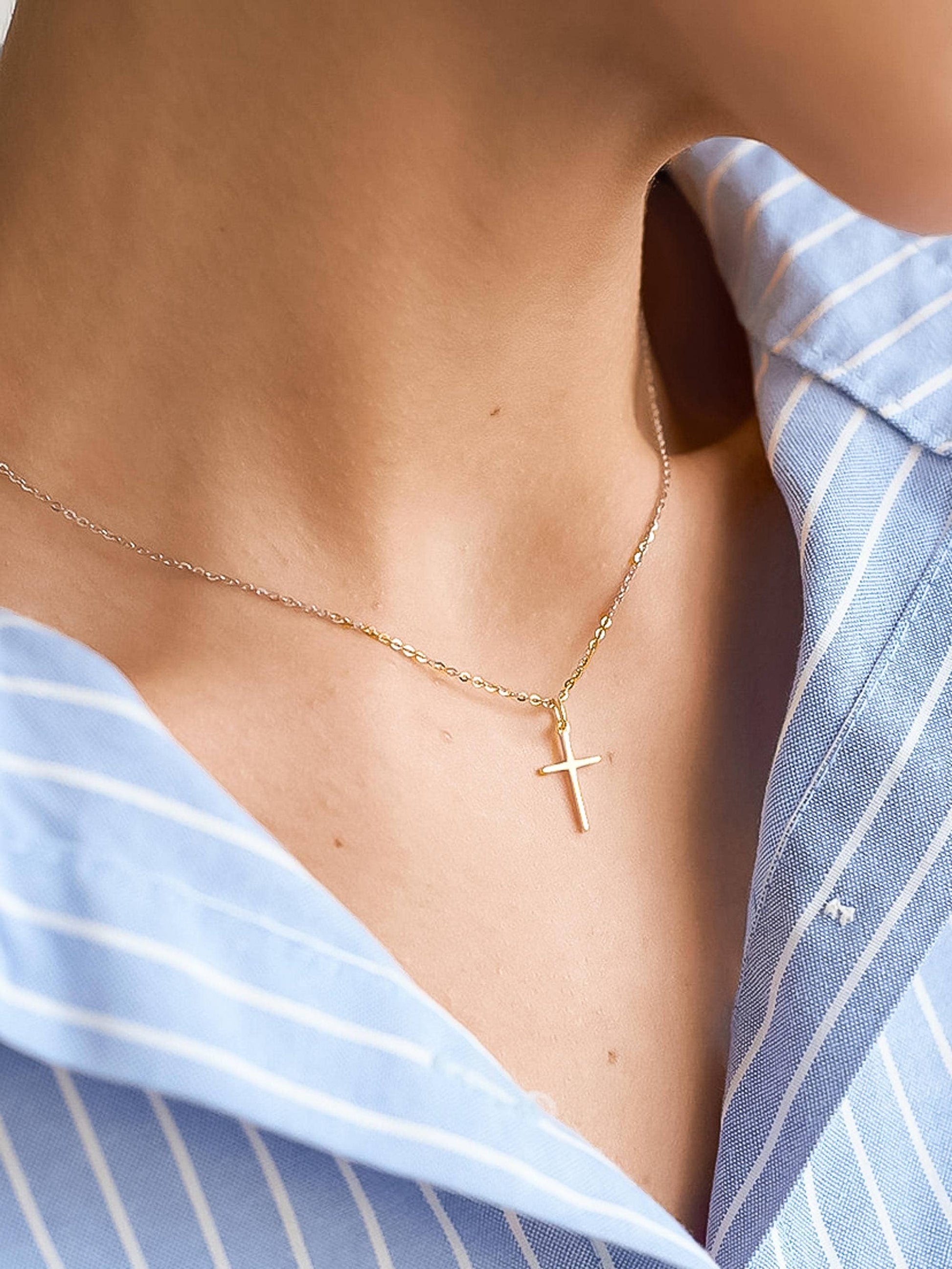 Small gold cross necklace by Flanerie in 18K gold with a non-tarnish finish, featuring a delicate chain and simple design