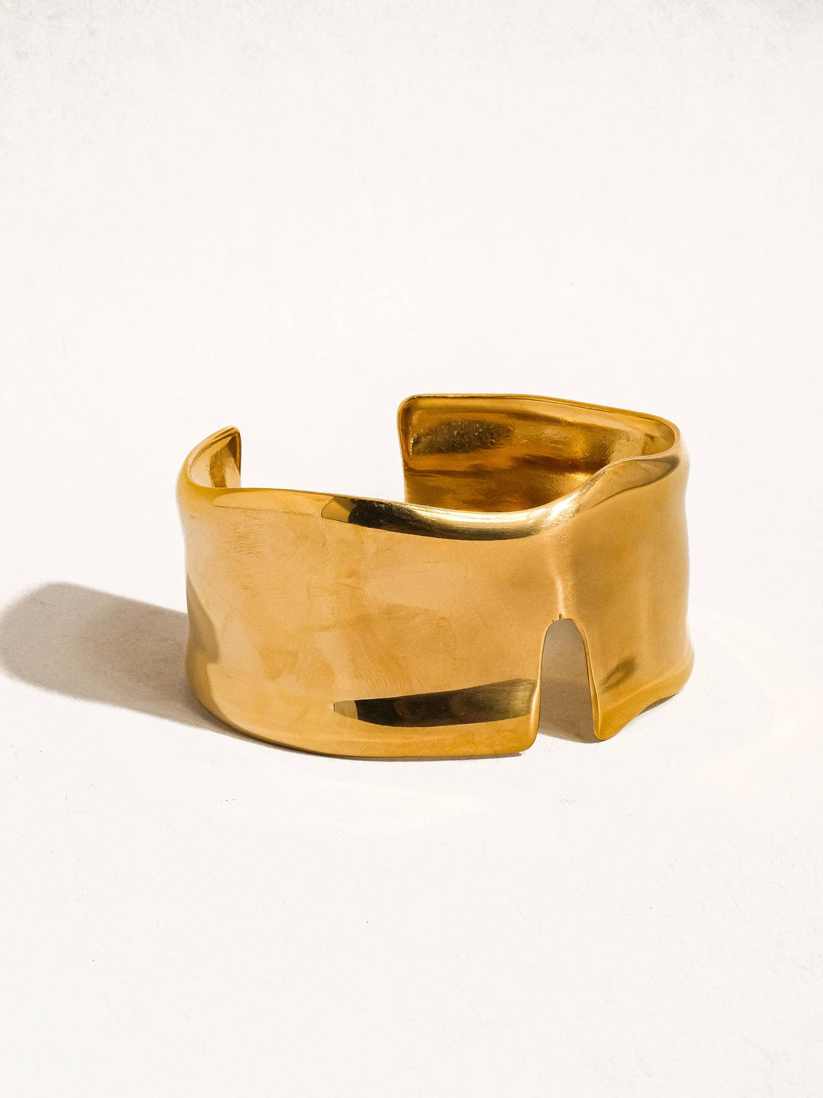 Water resistant 18K gold abstract bold bangle by Flanerie by MAIQ, featuring a modern, non-tarnish design with a sleek, artistic shape.