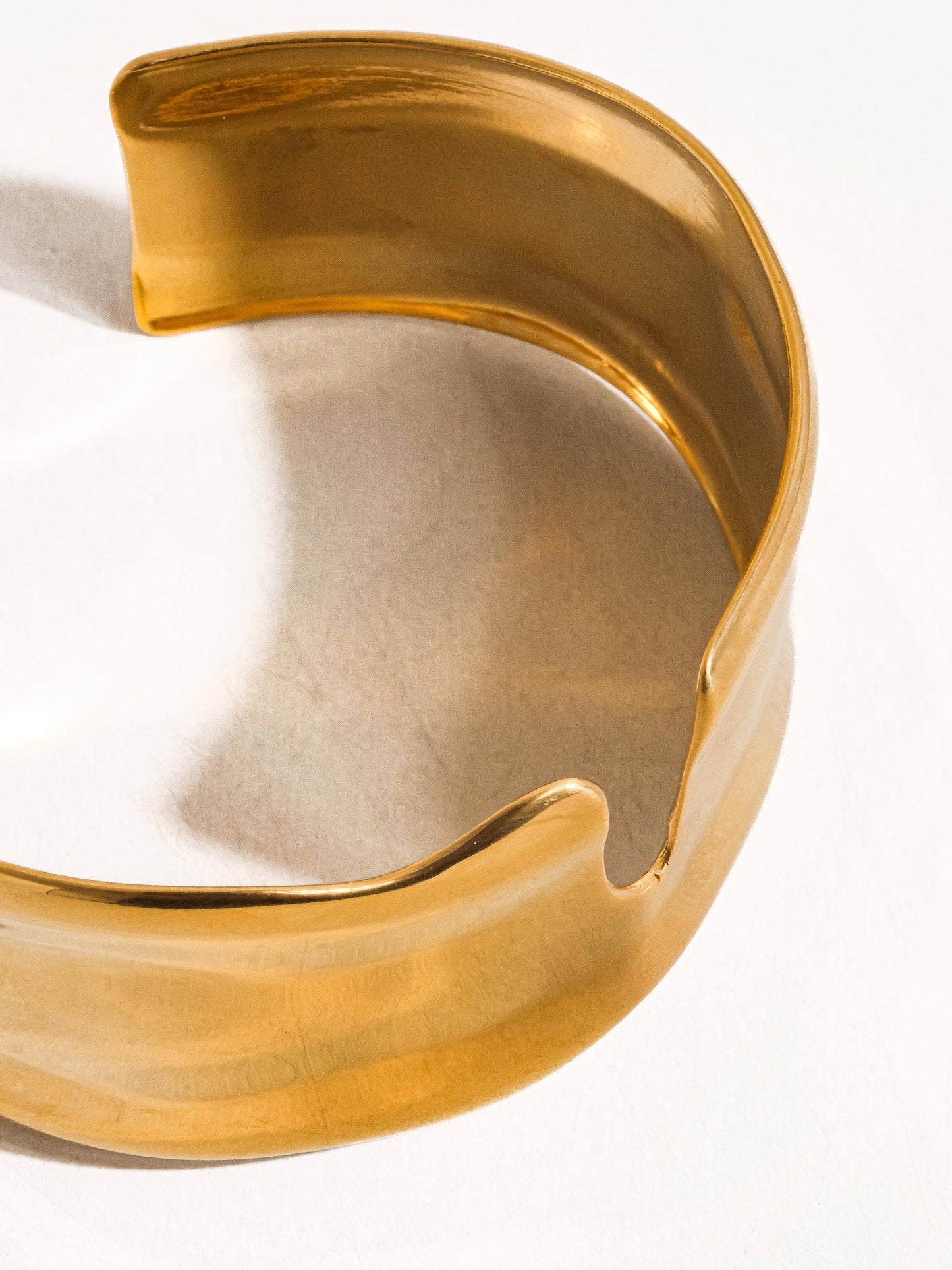 Water resistant 18K gold abstract bangle by Flanerie by MAIQ featuring bold, non-tarnish design with modern artistic style.