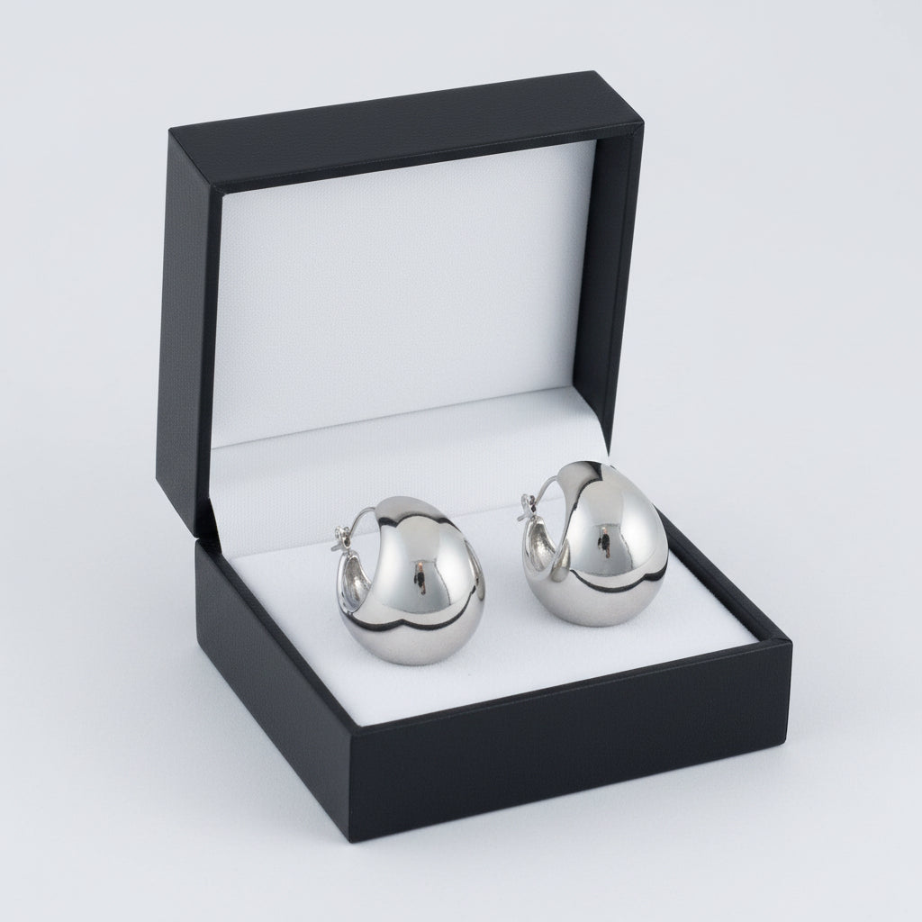 Narelle waterproof silver hoop earrings by Howard's featuring round bowl-shaped design on a white background.