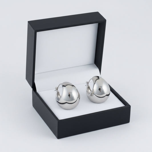 Narelle waterproof silver hoop earrings by Howard's featuring round bowl-shaped design on a white background.