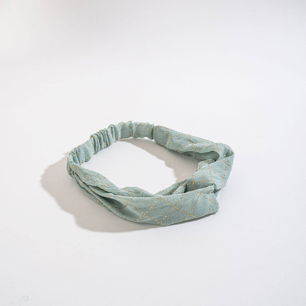 Howard's Peyton Twist Headband featuring a stylish twisted design in vibrant fabric, perfect for adding a chic touch to any outfit.