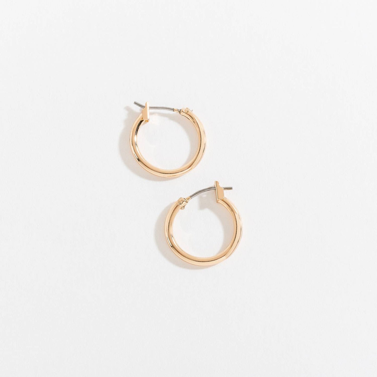Howard's Ear Sense Click Hoop Earrings displayed on a model, showcasing stylish gold-toned hoop earrings with secure click closures.
