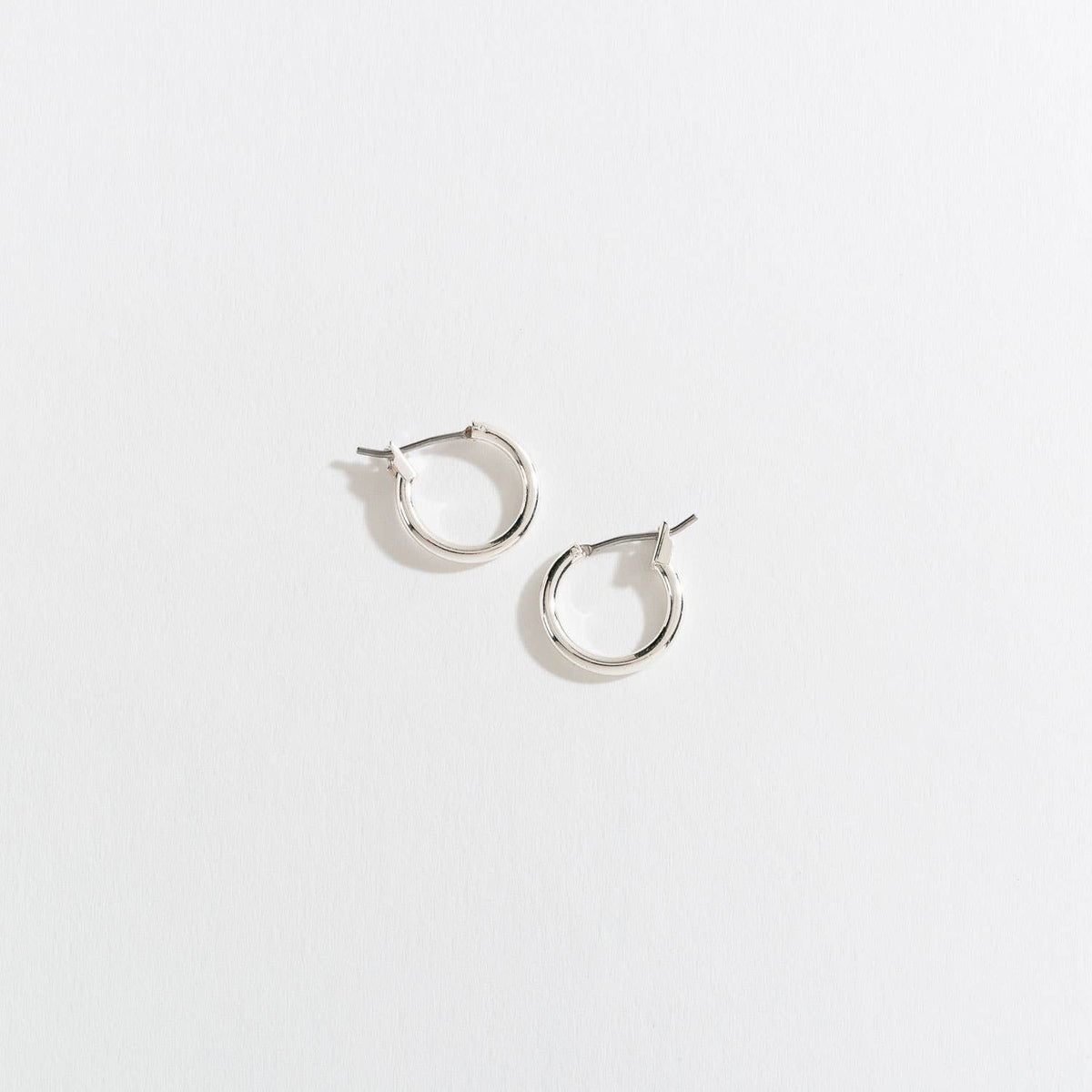 Howard's Ear Sense Click Hoop Earrings showcasing shiny silver hoops with secure click closures on a white background.