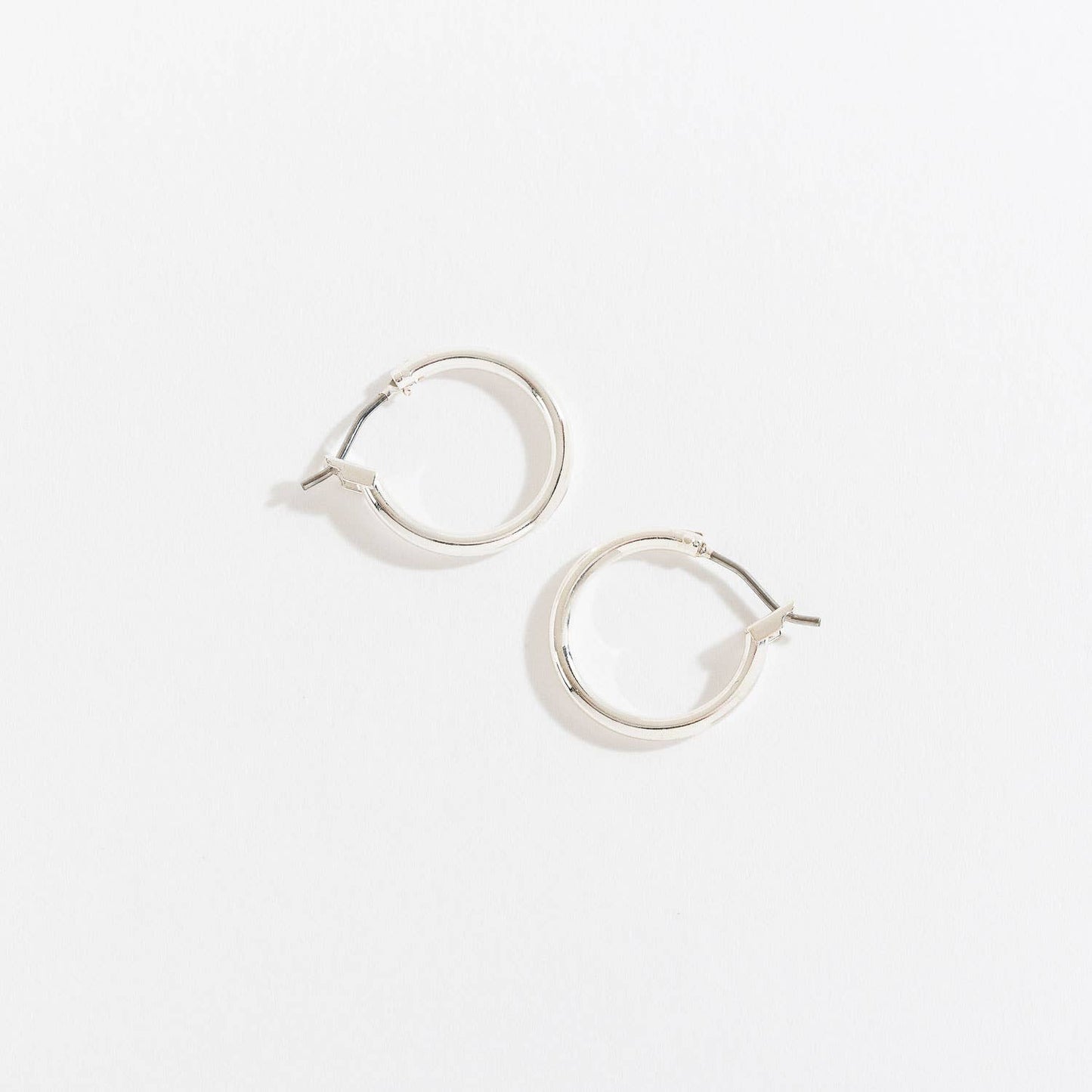 Howard's Ear Sense Click Hoop Earrings featuring sleek, silver-tone hoops with easy click-on closure.