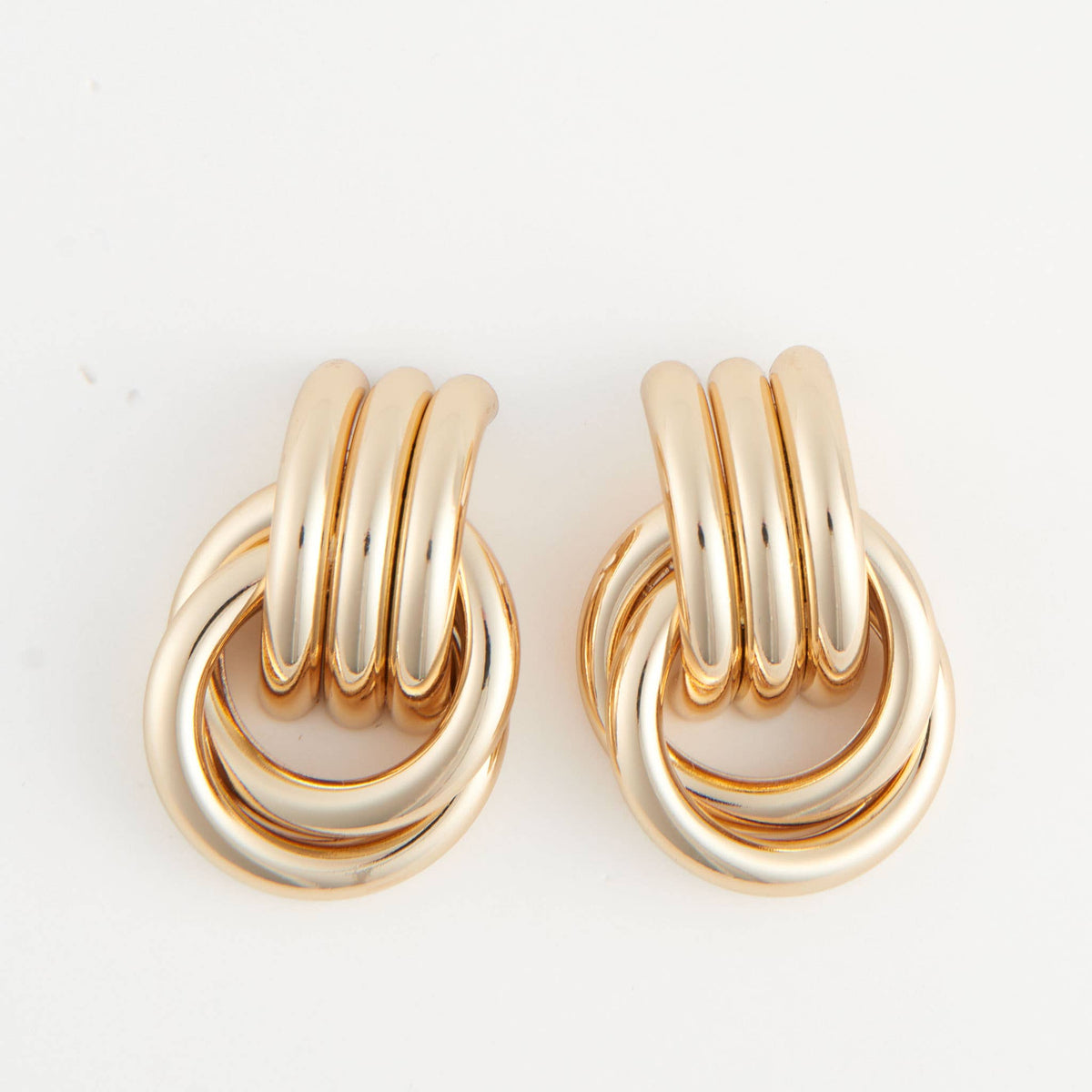 Howard's stud earrings featuring interlocking triple knot design in silver, showcasing a sleek and modern jewelry style.