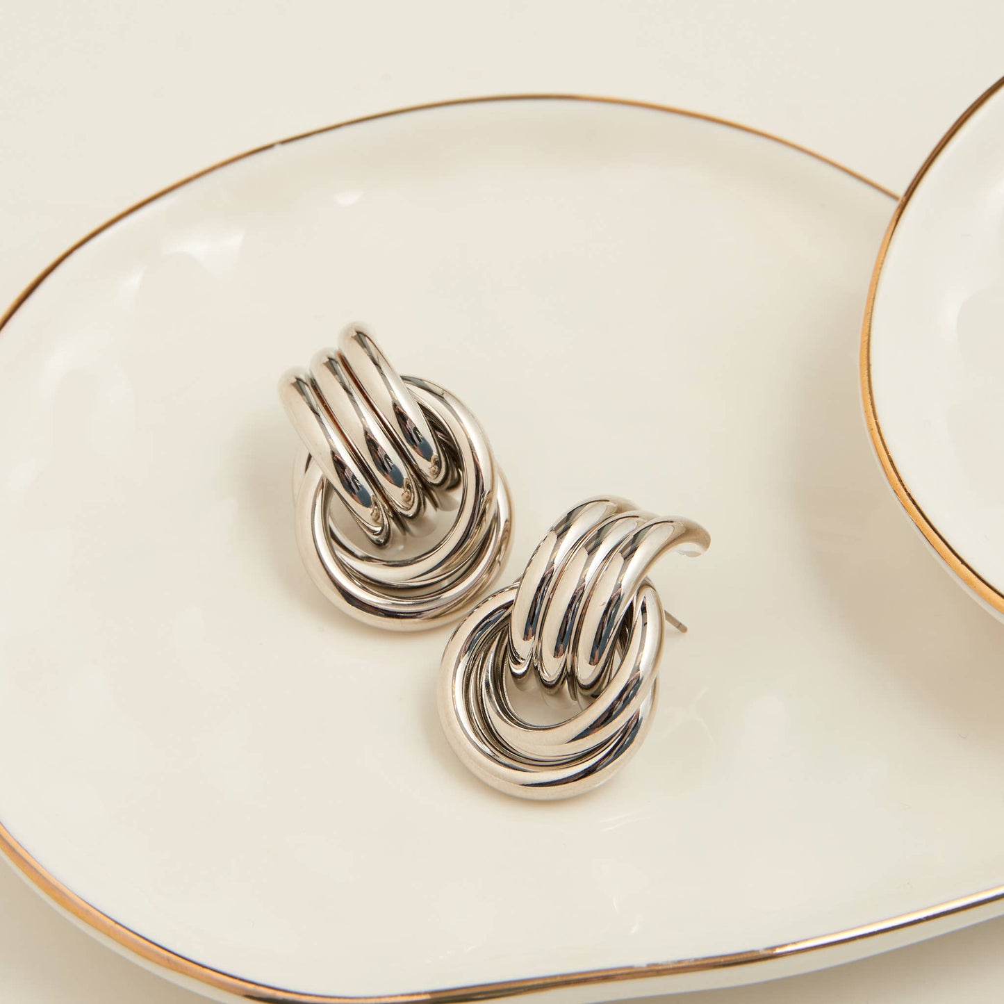Howard's Solara interlocking triple knot stud earrings featuring sleek silver design and secure post back for everyday wear.