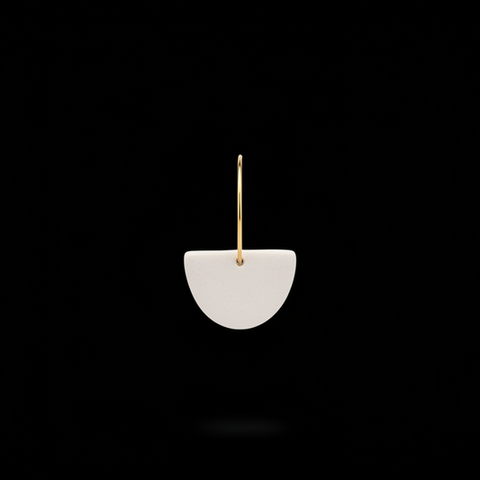 Jax Kelley clay half moon sculpture in oat milk color, featuring smooth curves and a matte finish on a neutral background.
