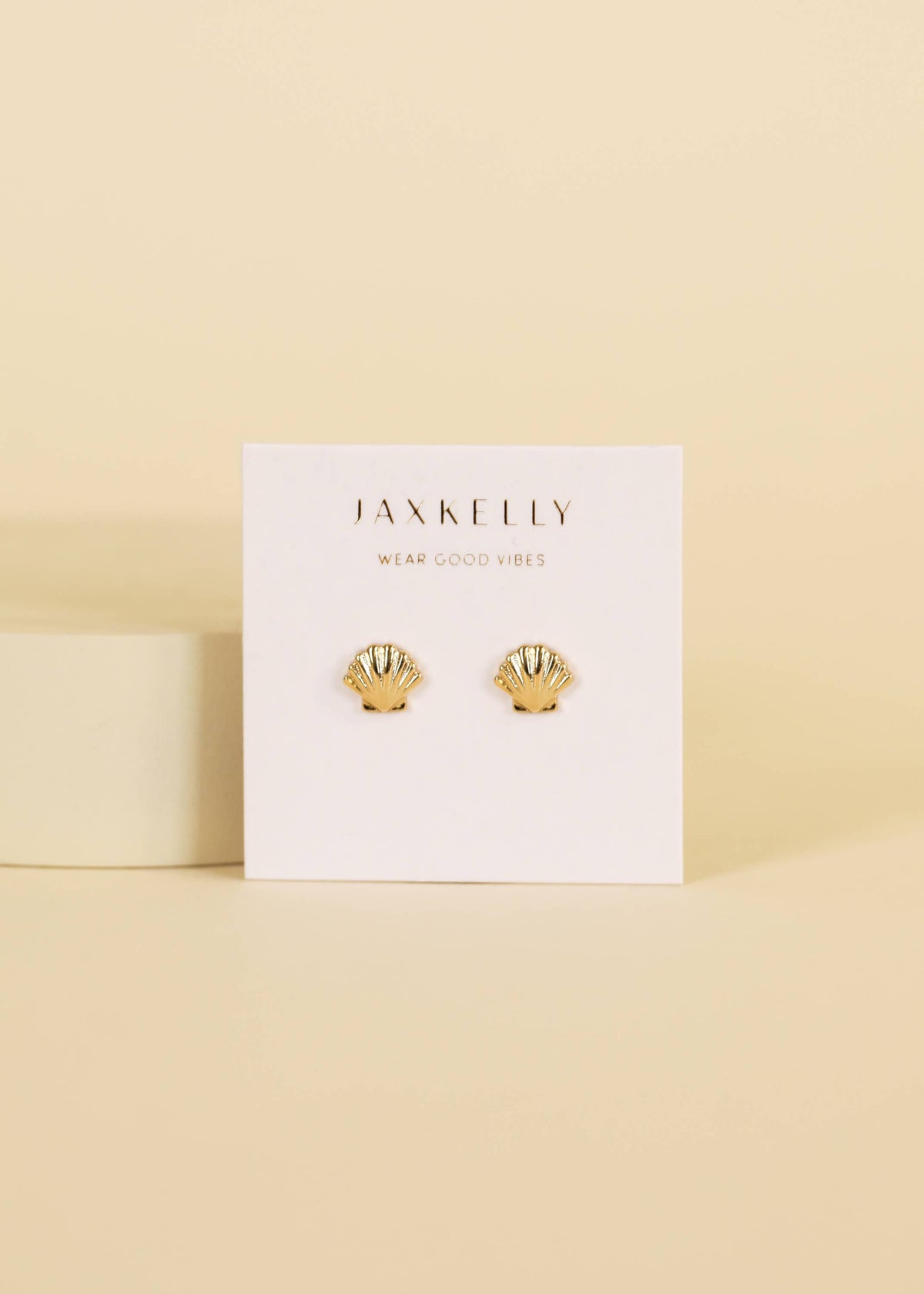 Gold earrings featuring seashell designs by Jax Kelley, showcasing delicate seashell-shaped jewelry with a shiny gold finish.