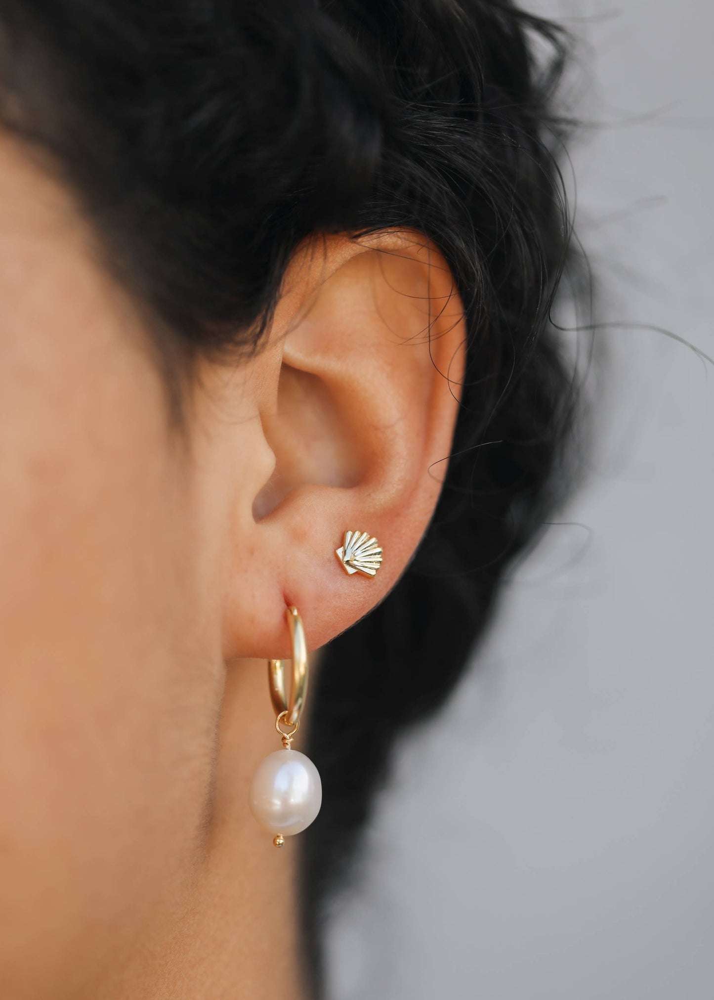 Gold seashell earrings by Jax Kelley featuring delicate seashell designs on elegant gold hoops.