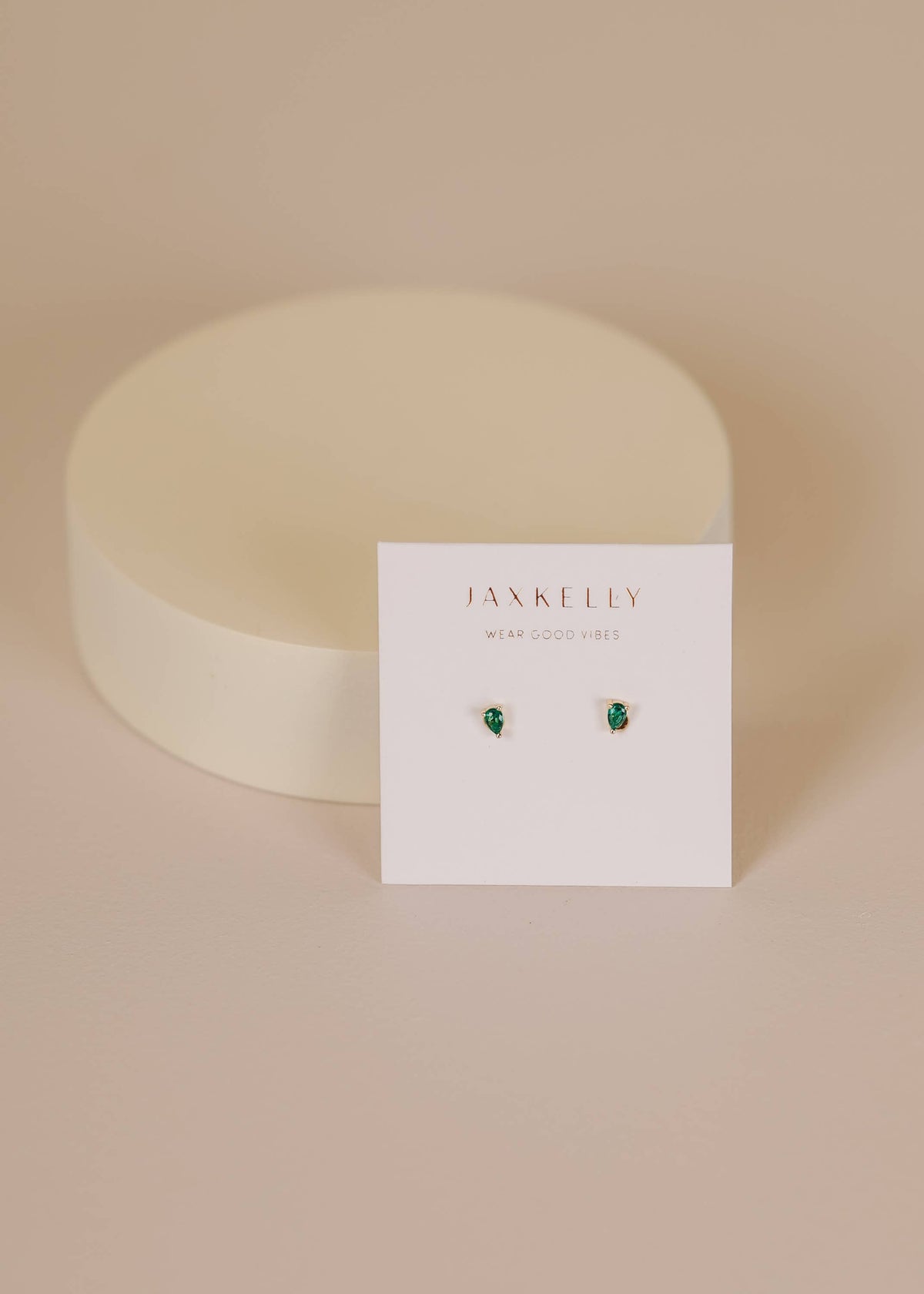 Jax Kelley teardrop earrings with emerald cubic zirconia stones, featuring elegant silver hooks and a sleek, polished finish.