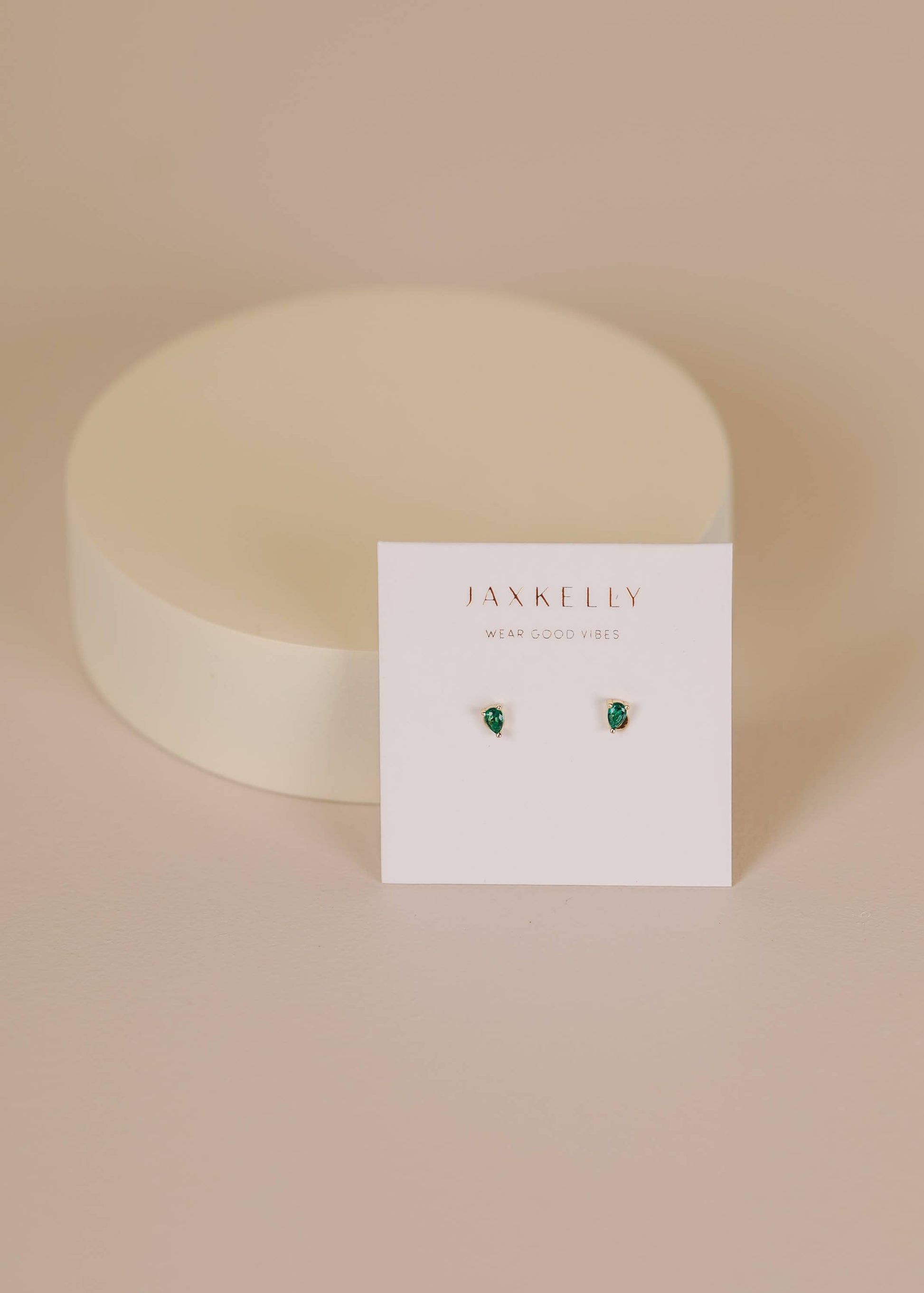Jax Kelley teardrop earrings with emerald cubic zirconia stones, featuring elegant silver hooks and a sleek, polished finish.
