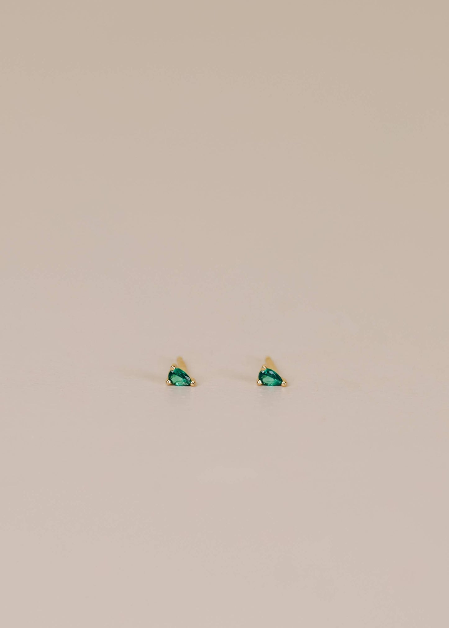 Jax Kelley teardrop earrings featuring emerald cubic zirconia stones, elegant and sparkling jewelry accessory.