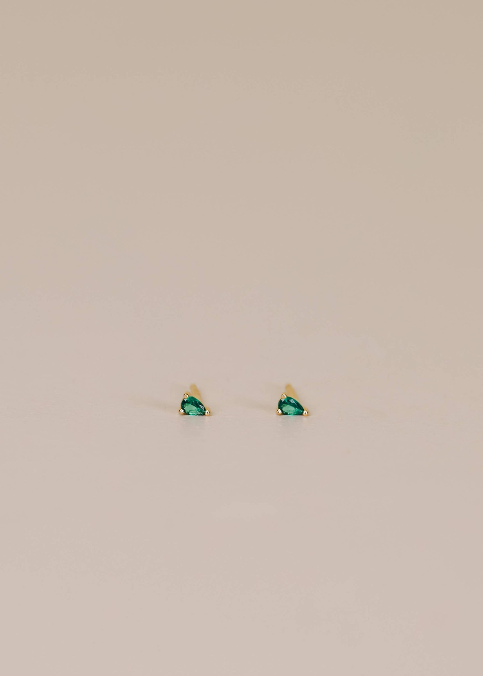 Jax Kelley teardrop earrings featuring emerald cubic zirconia stones, elegant and sparkling jewelry accessory.