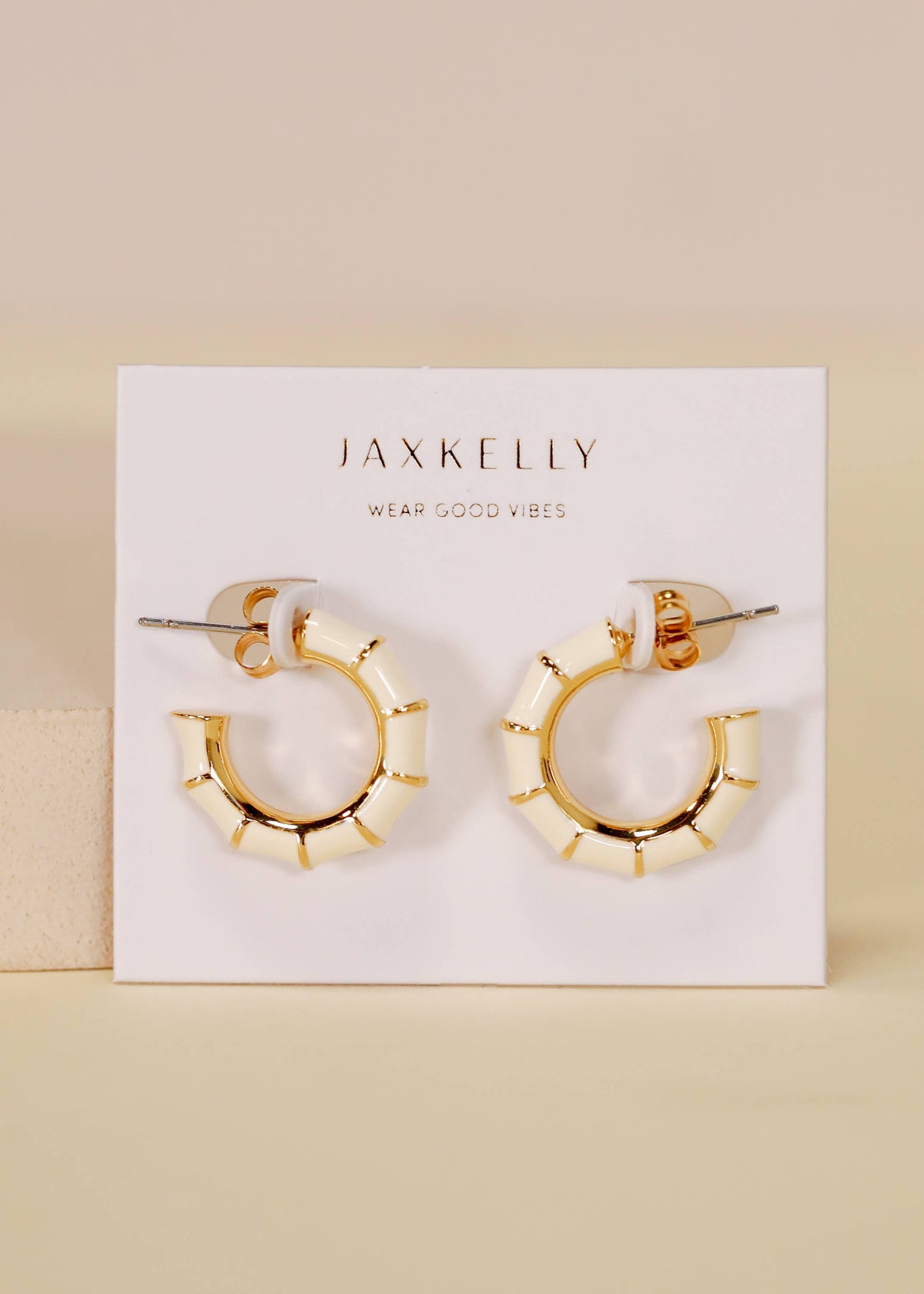 Vintage hoop earrings by Jax Kelley featuring cream enamel finish and classic round design.
