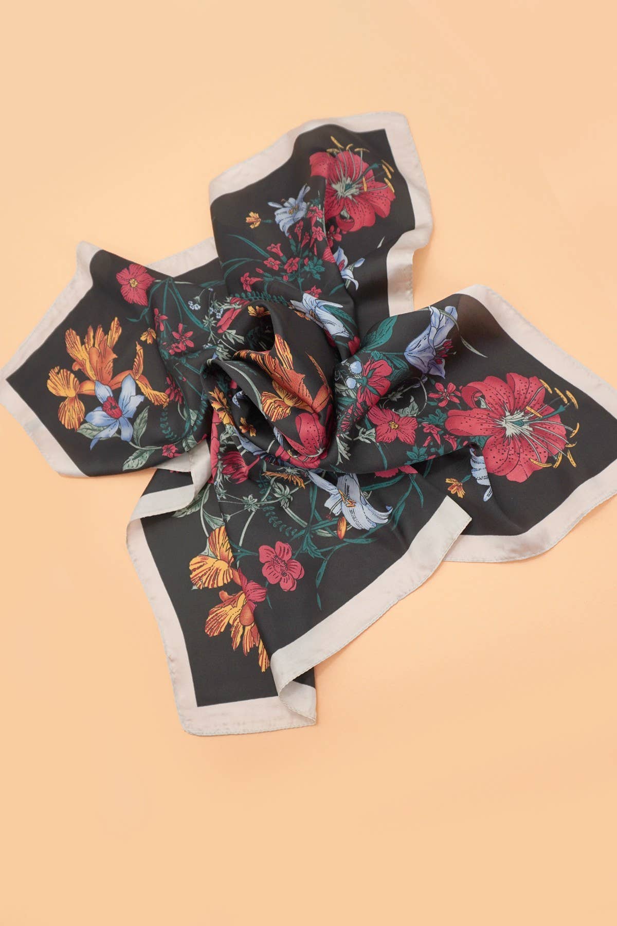 Large floral print bandana scarf by JOSSLYN featuring vibrant floral patterns and soft fabric, shown draped and spread.