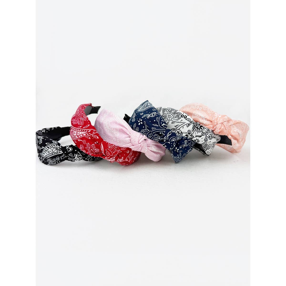 Love and Repeat bandana knot hairband featuring a colorful, patterned fabric with a stylish knot detail on top.