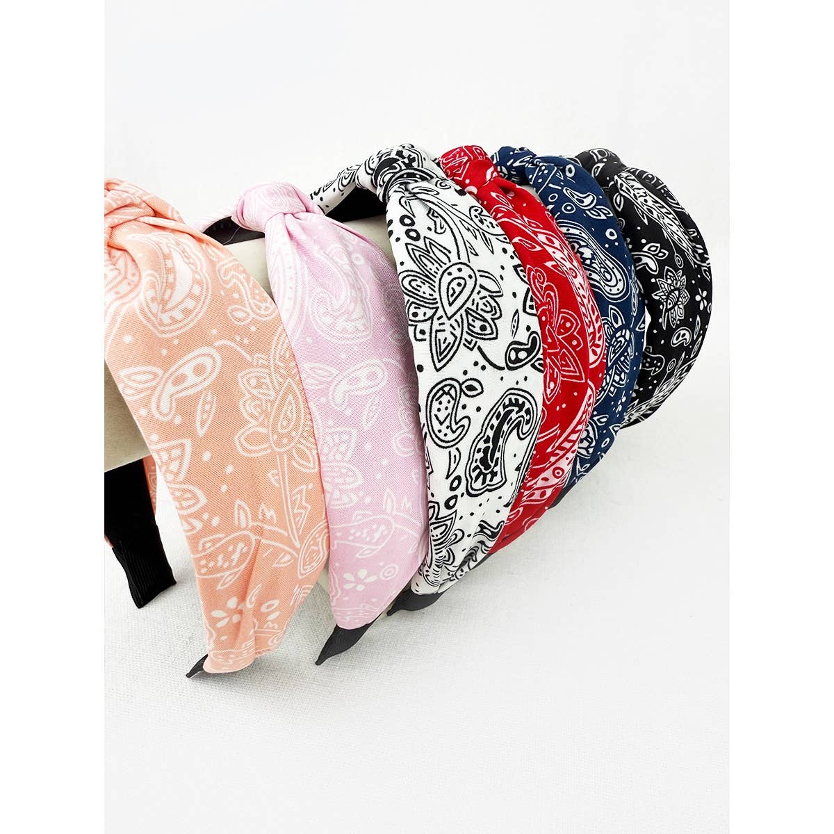Love and Repeat bandana knot hairband with colorful fabric design, styled on a model's head.