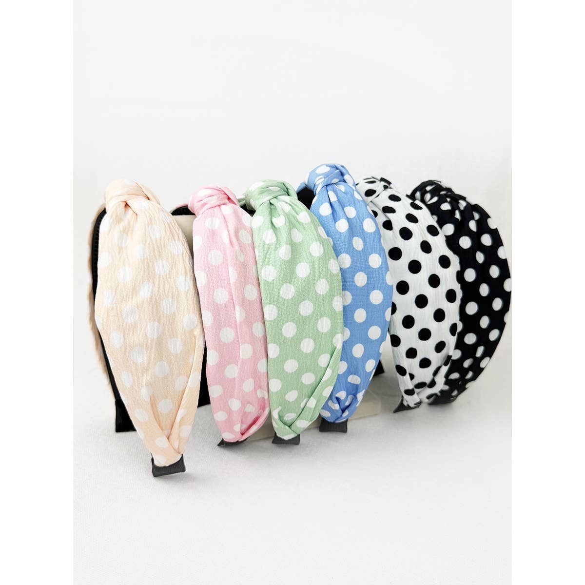 Love and Repeat polkadot print knot hairband with black and white polka dots on fabric, styled for a casual look.