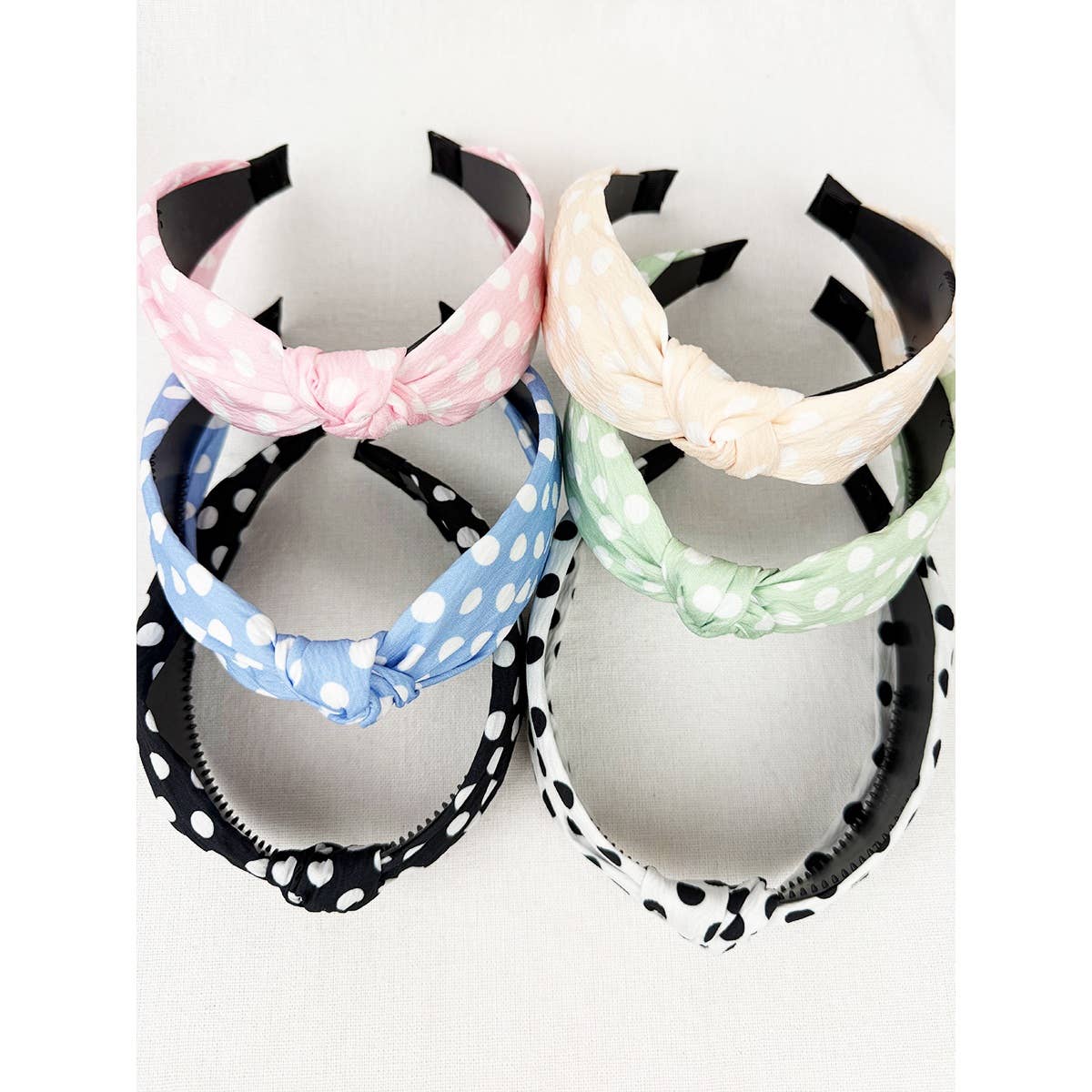 Polkadot print knot hairband by Love and Repeat, featuring a stylish fabric design with a knot detail on a neutral background.