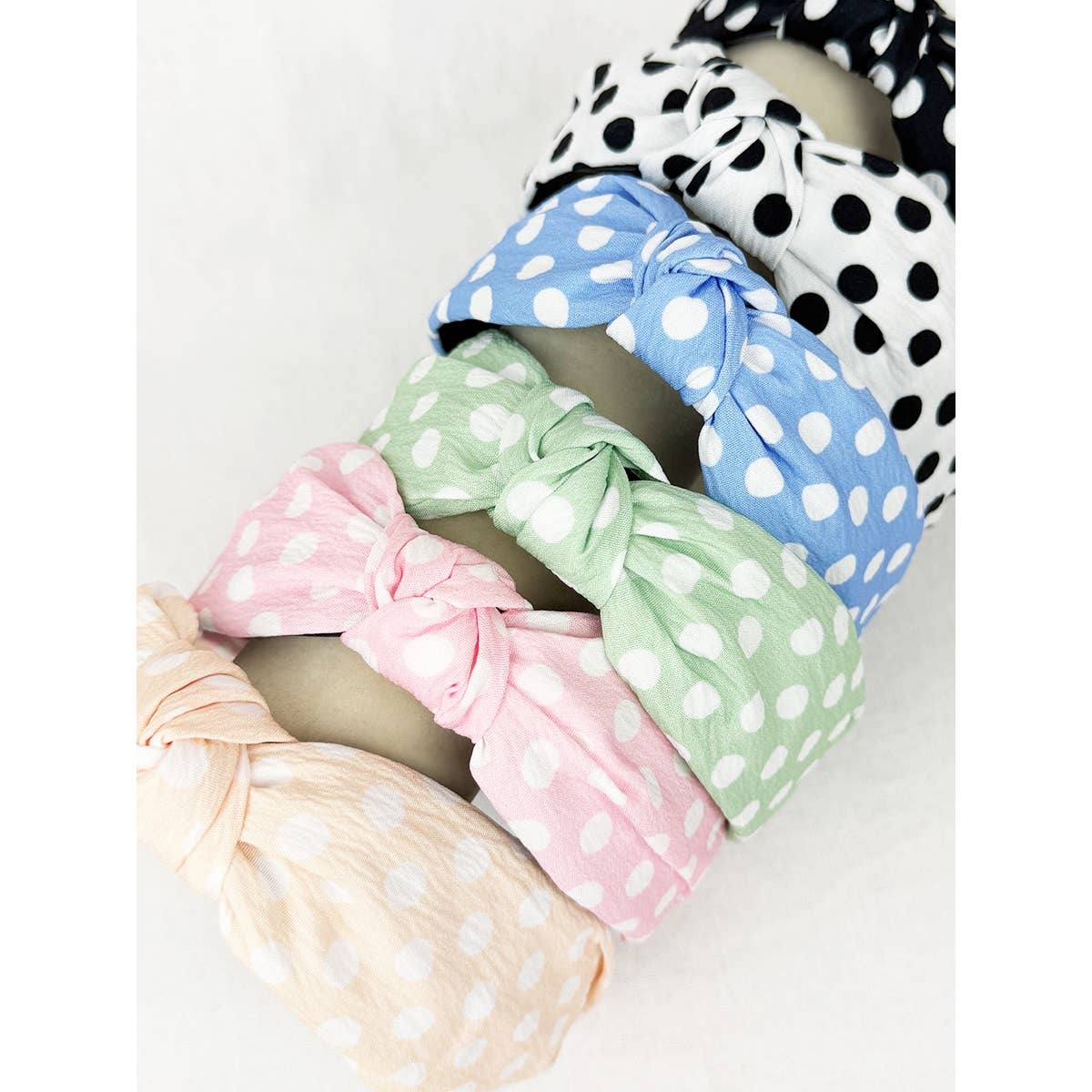 Polkadot print knot hairband by Love and Repeat featuring a stylish polka dot pattern and a knotted design.
