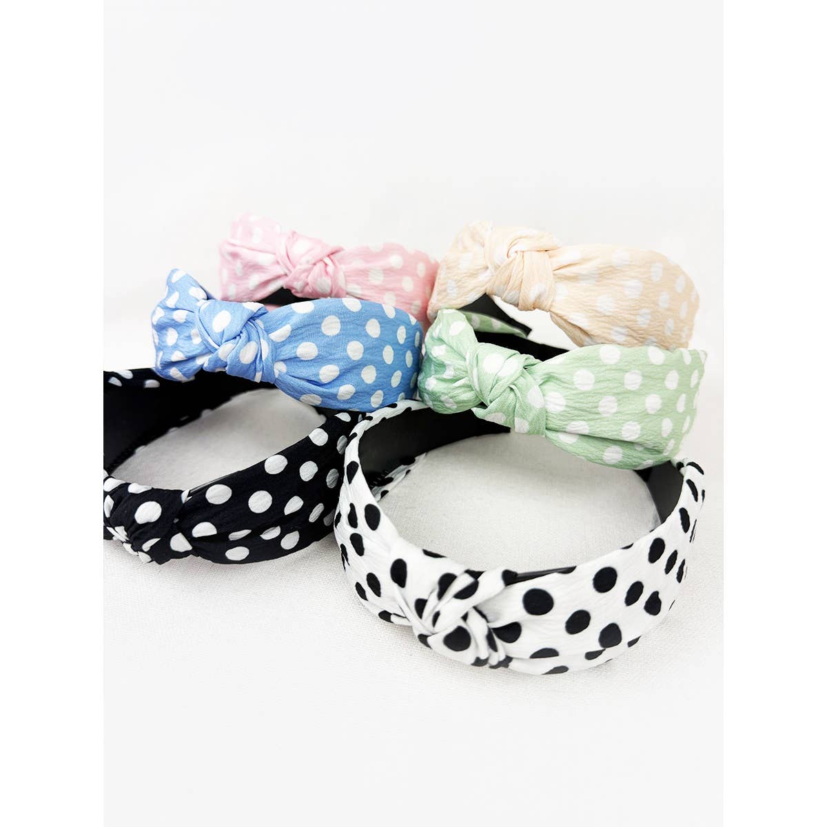 Polkadot print knot hairband by Love and Repeat featuring a black and white polka dot design on soft fabric.