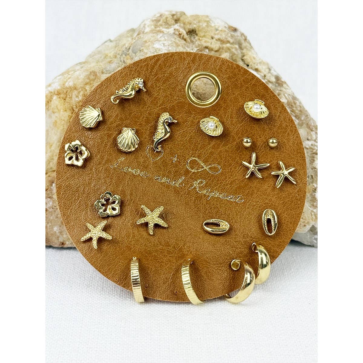 Beach-themed earrings by Love and Repeat featuring seashell and starfish designs, perfect for summer accessories.
