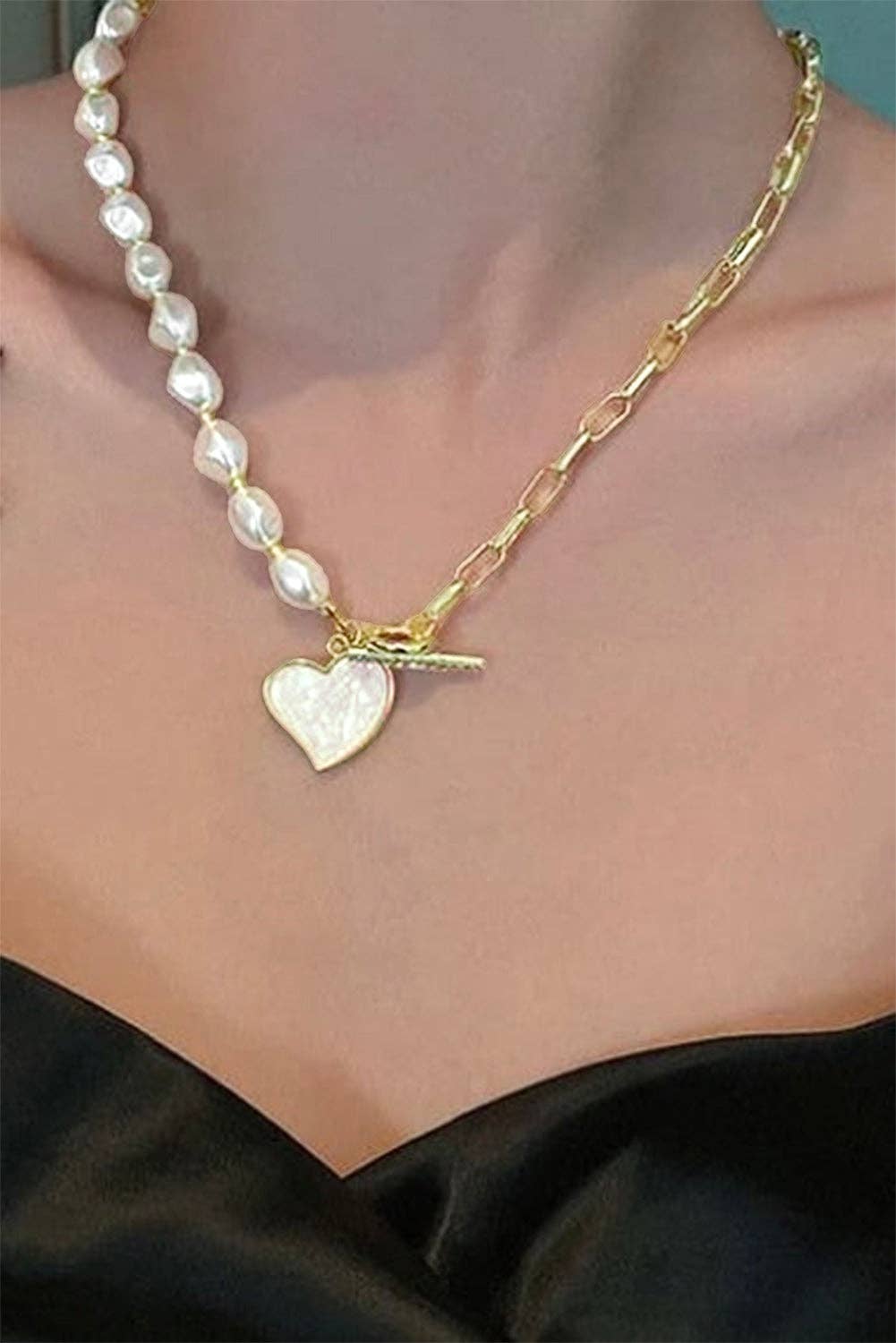 Gold heart-shaped pendant necklace with rhinestone accents and pearl chain from Lovesoft, showcasing the detailed jewelry design.