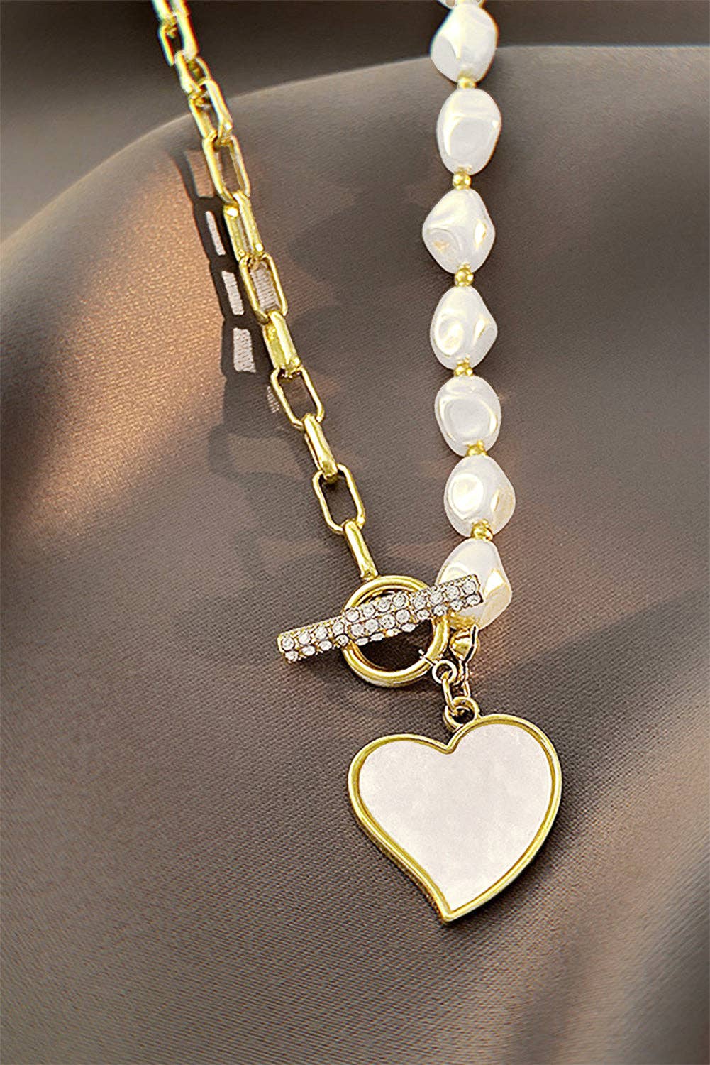 Gold heart-shaped pendant necklace with rhinestone accents and pearl chain, elegant jewelry by Lovesoft.