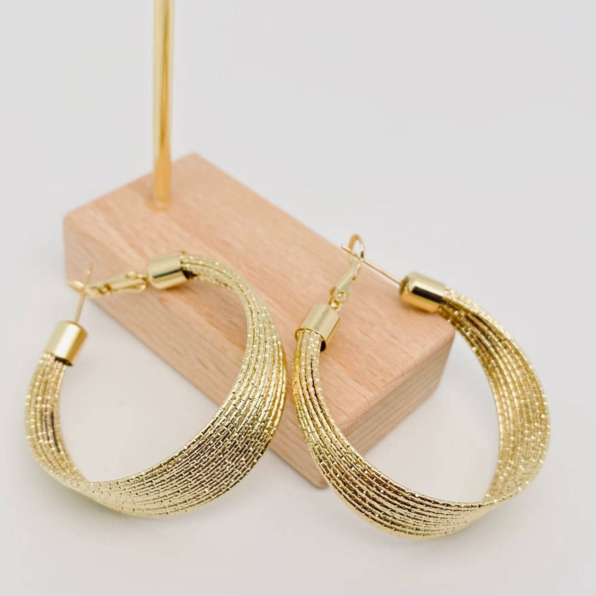 Golden multi-layer coil hoop earring by Mio Queena, showcasing layered gold-toned coils with a stylish, contemporary design.