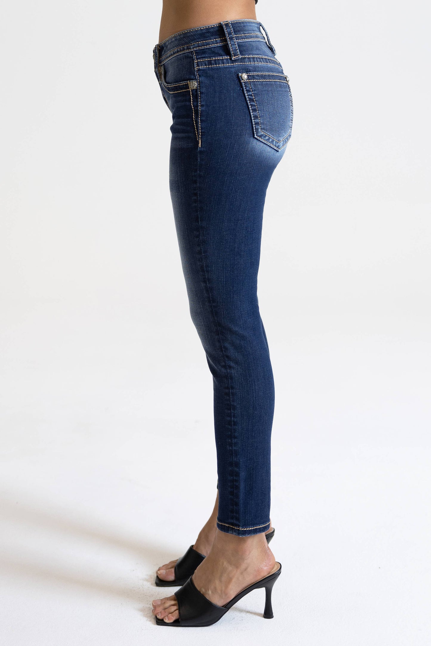 Miss Me 29-inch midrise skinny jeans in dark wash with subtle fading and classic five-pocket style, displayed on a hanger.