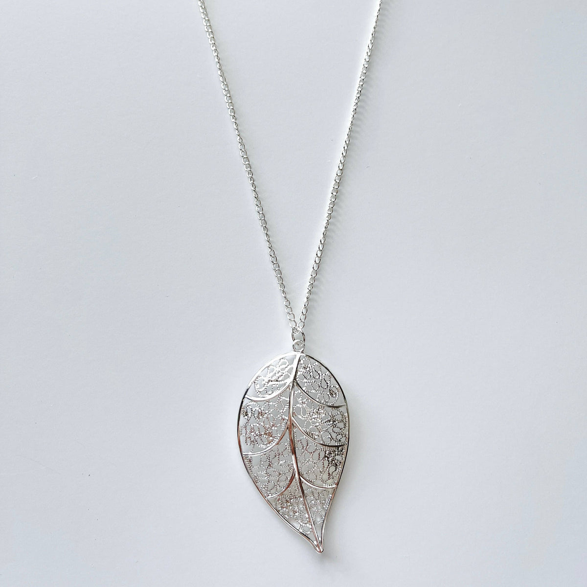 Long chain necklace with a detailed leaf pendant, stylish fashion jewelry by My Store featuring an elegant nature-inspired design.