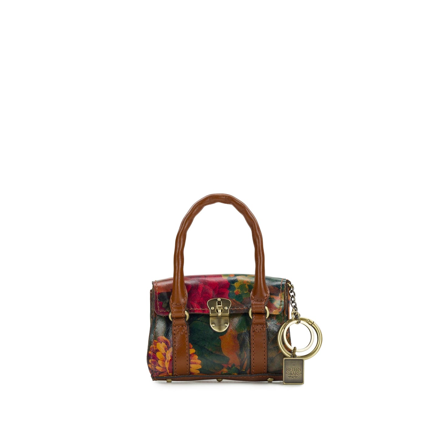 Patricia Nash Mini Vienna Bag Charm with leather detailing and decorative metal accents, hanging from a handbag.