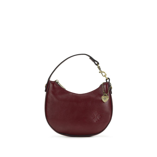 Patricia Nash Mini Morgana Bag Charm with leather details and decorative metal accents hanging from a purse strap.