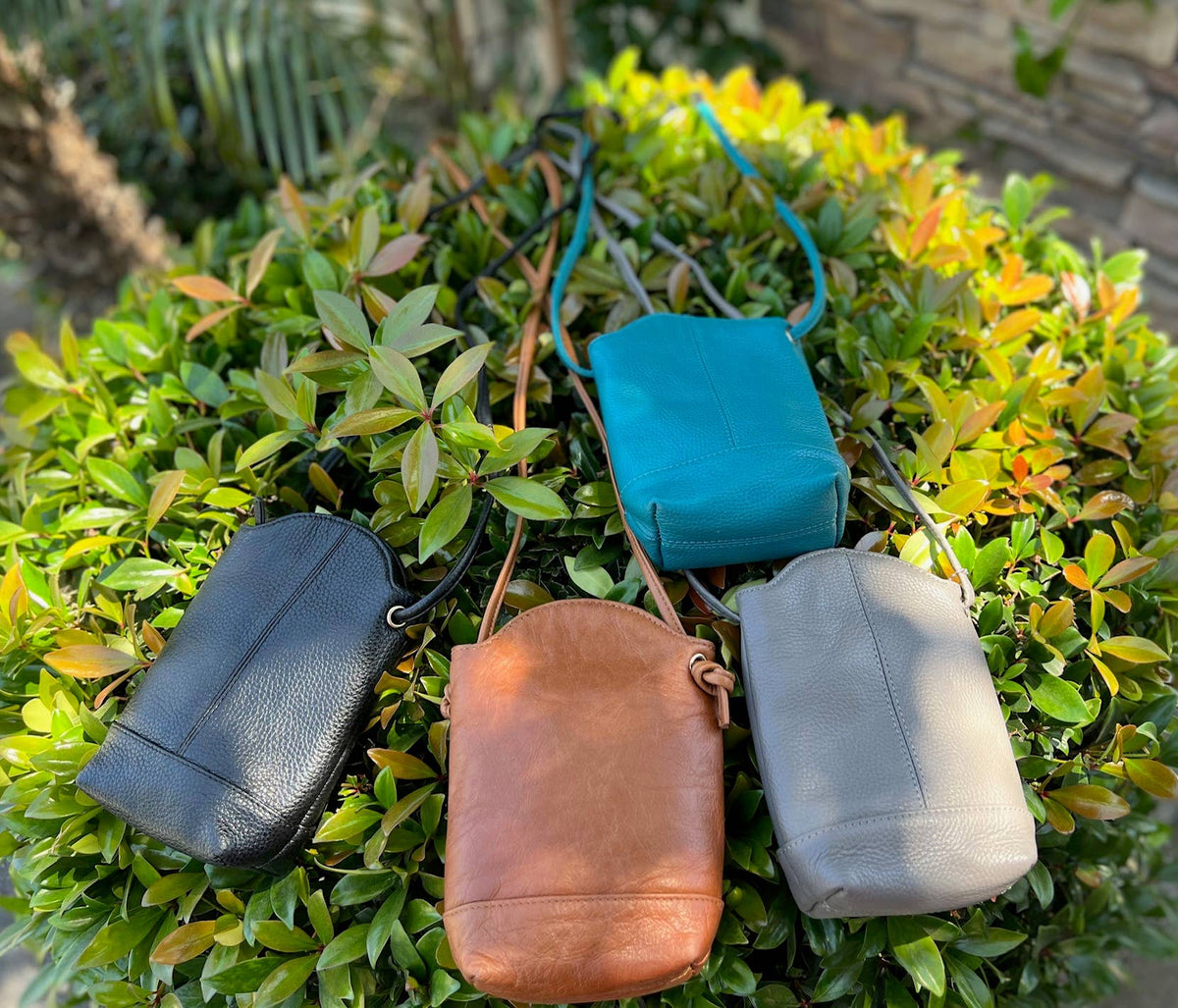 Small cowhide leather crossbody bag for phone by Roma Leathers, Inc., featuring a compact design and adjustable strap.