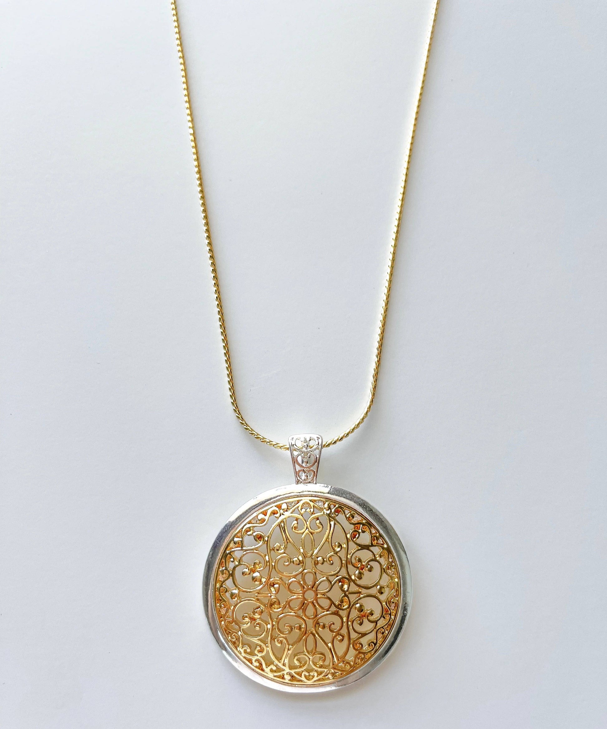 Two-toned domed filigree pendant on a long chain necklace by S & A Fashions, featuring intricate metalwork and elegant design.