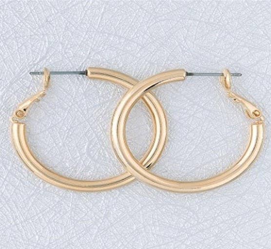 Large gold tubular hoop earrings from S&A Fashions, showcasing shiny, bold circular jewelry with smooth, polished surface.