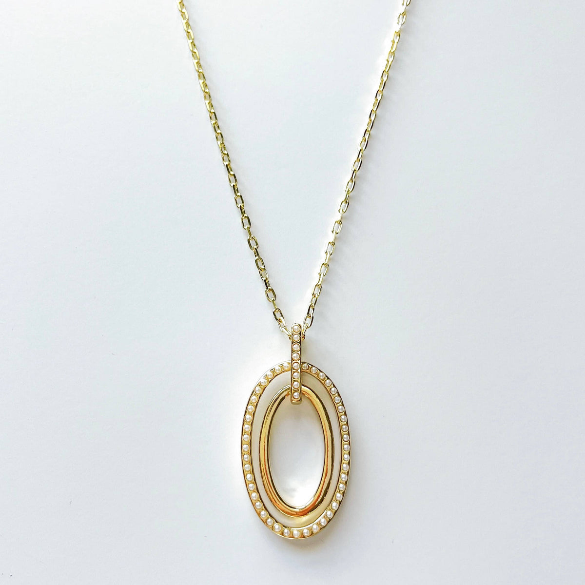 Double oval pendant necklace with mini faux pearls by S & A Fashions, featuring elegant silver-tone chain and detailed design.