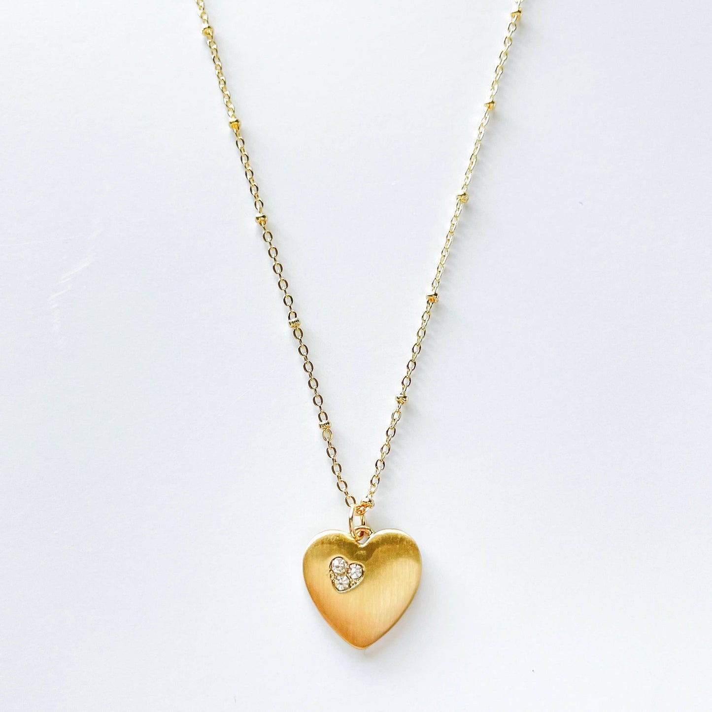 S & A Fashions fashion heart-shaped stone pendant necklace hanging on a chain, close-up view of the jewelry accessory.