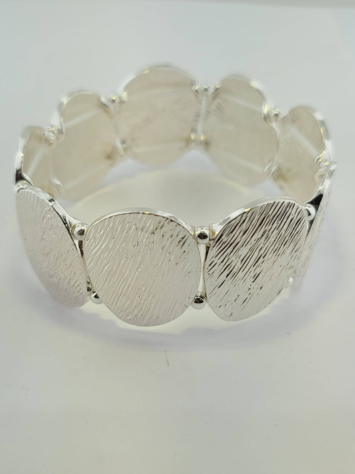 Silver textured oval stretch bracelet by S & A Fashions, featuring oval-shaped beads on a flexible elastic band.