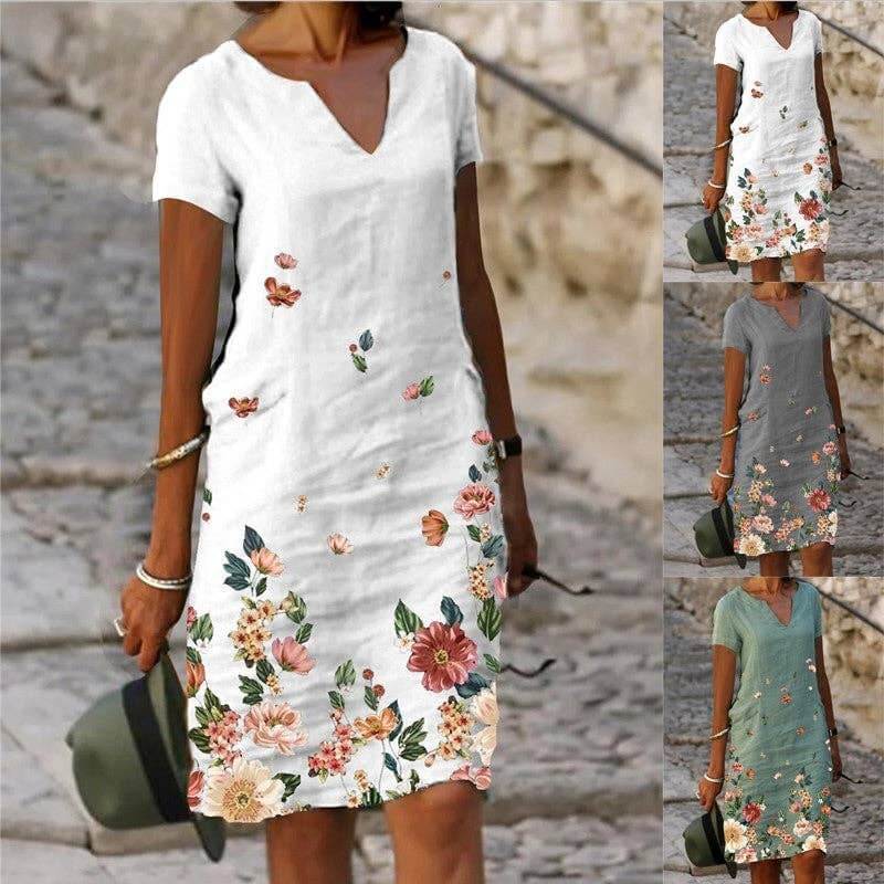Floral printed short-sleeve V-neck dress by SALINA TRADING INC with colorful flower pattern and flowing fabric.