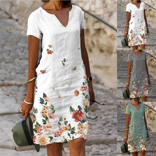 Floral printed short-sleeve V-neck dress by SALINA TRADING INC with colorful flower pattern and flowing fabric.