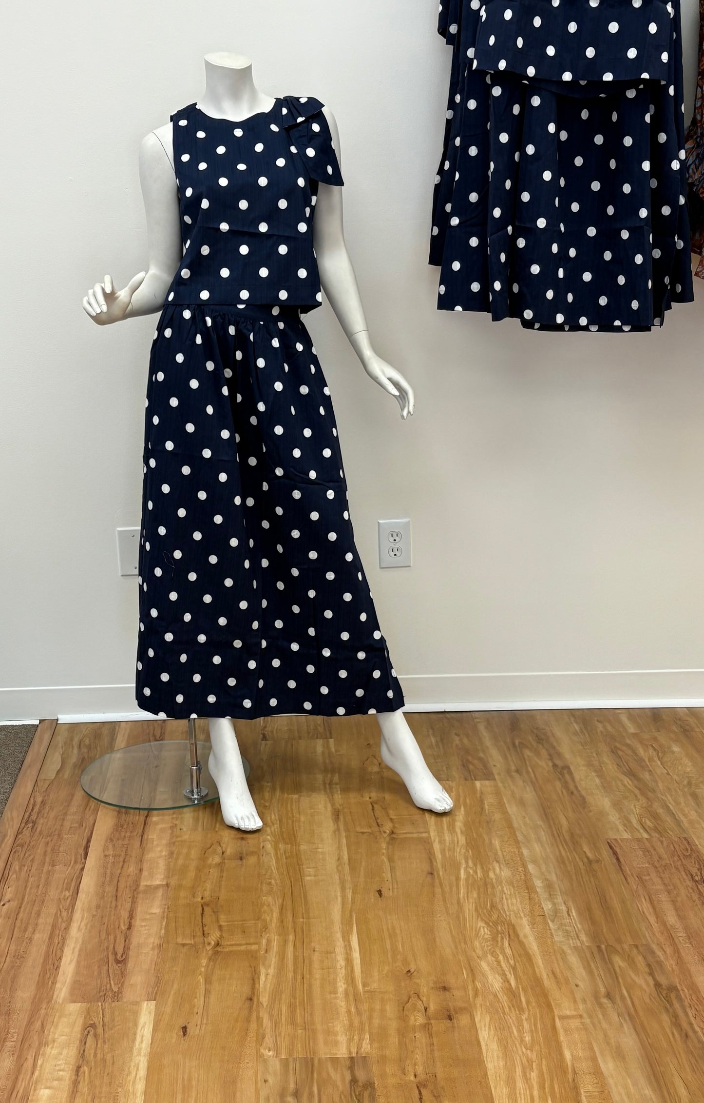 Sugarl!ps Caryn polka dot sleeveless top with a fitted neckline and playful dot pattern, shown on a model.