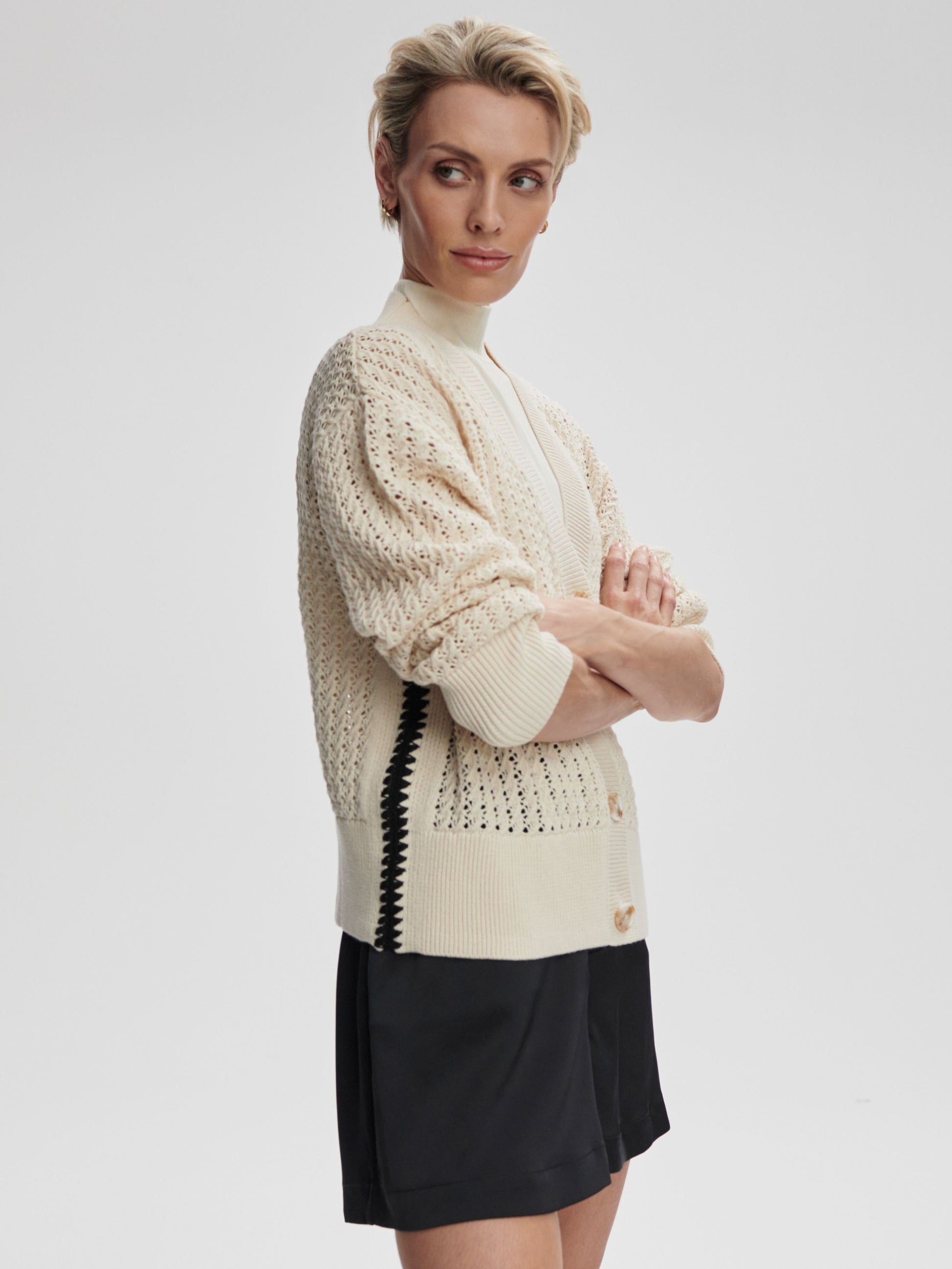 A Varley Astell relaxed knit cardigan in birch color, shown draped on a model with a cozy, casual fit.