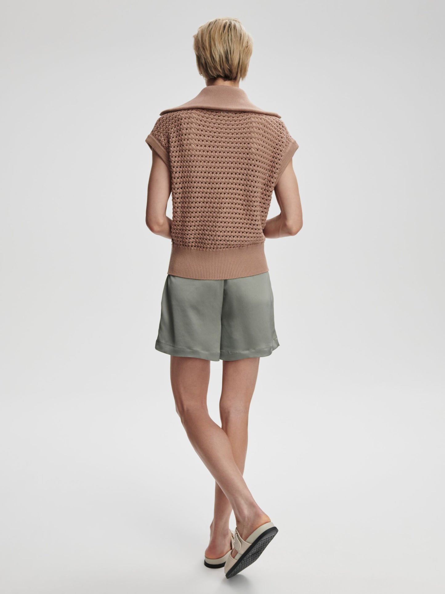Varley Liliana knit gilet displayed on a model, featuring a cozy, sleeveless knitwear design in a neutral color.